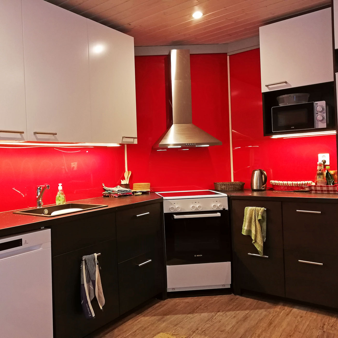 Kunststoffverarbeitung: Küchenrückwand aus rotem Acryl und Steckdosen
