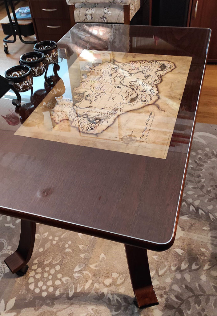Akryylinen pöydän suojalevy jonka alla on Skyrim-pelin kartta